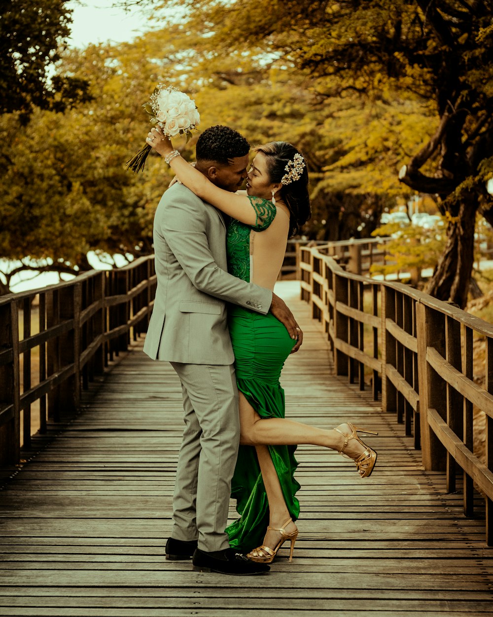 a man and a woman are hugging on a bridge