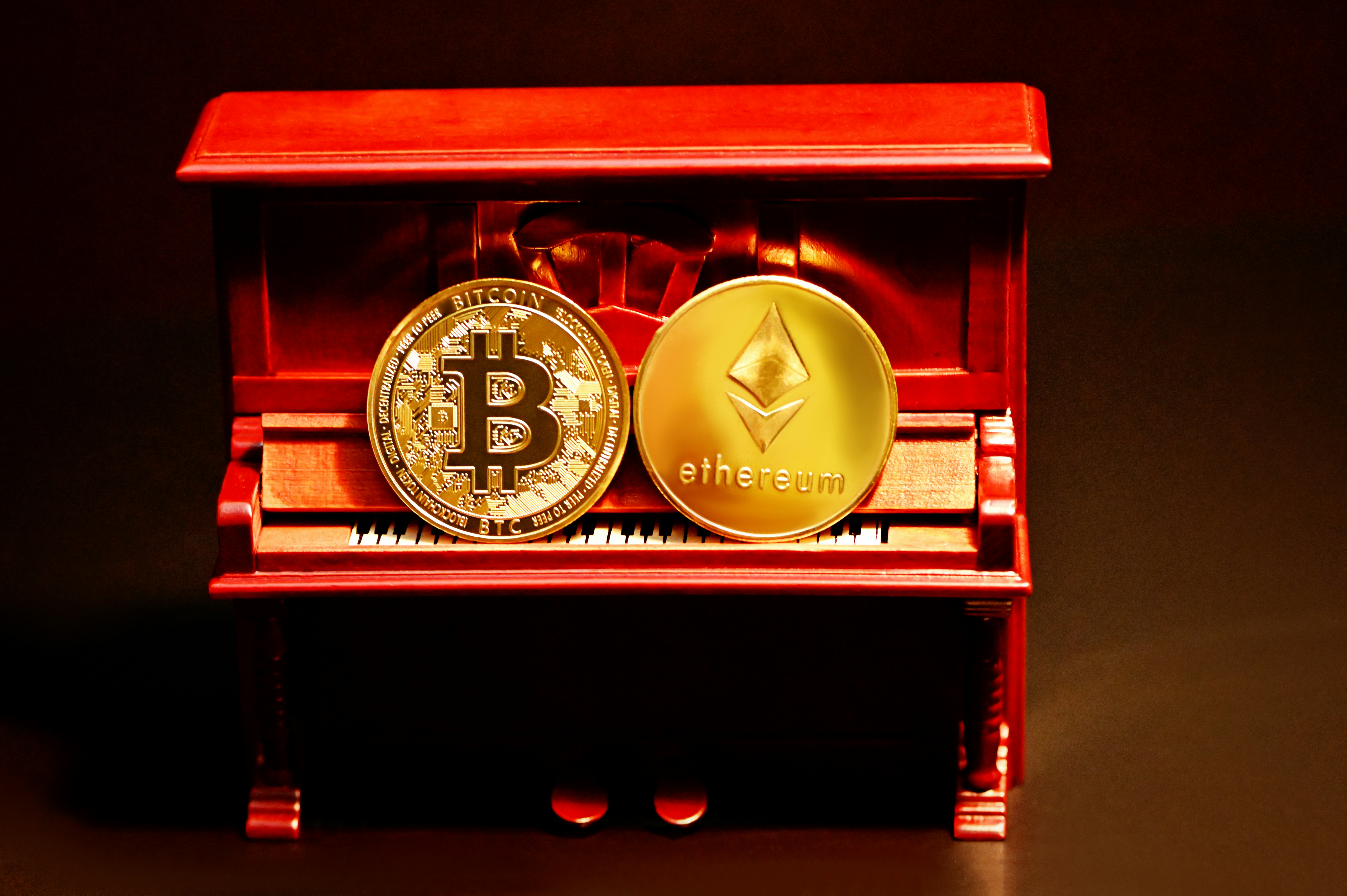 Bitcoin and Ethereum coin on top of a piano