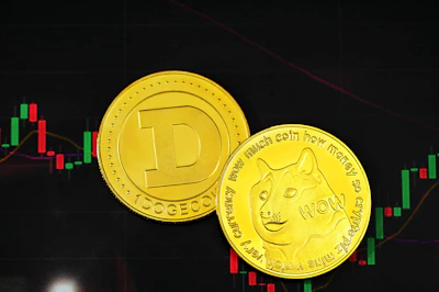 a close up of two gold coins near a stock chart