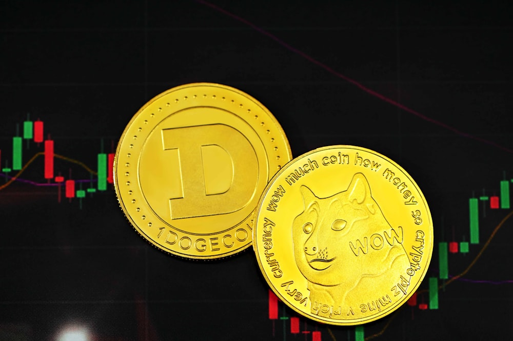 um close up de duas moedas de ouro perto de um gráfico de ações