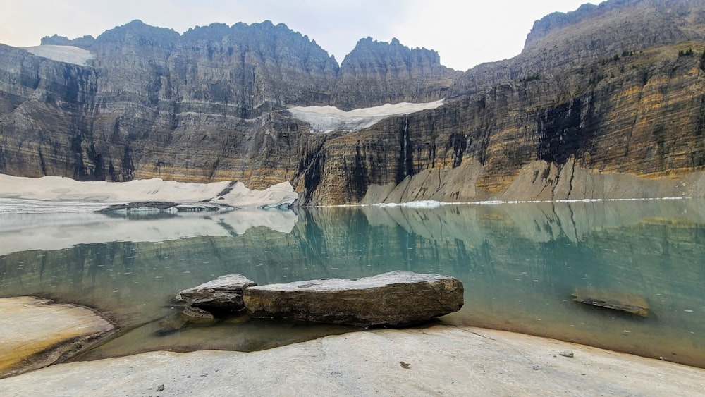 una grande roccia seduta sulla cima di un lago
