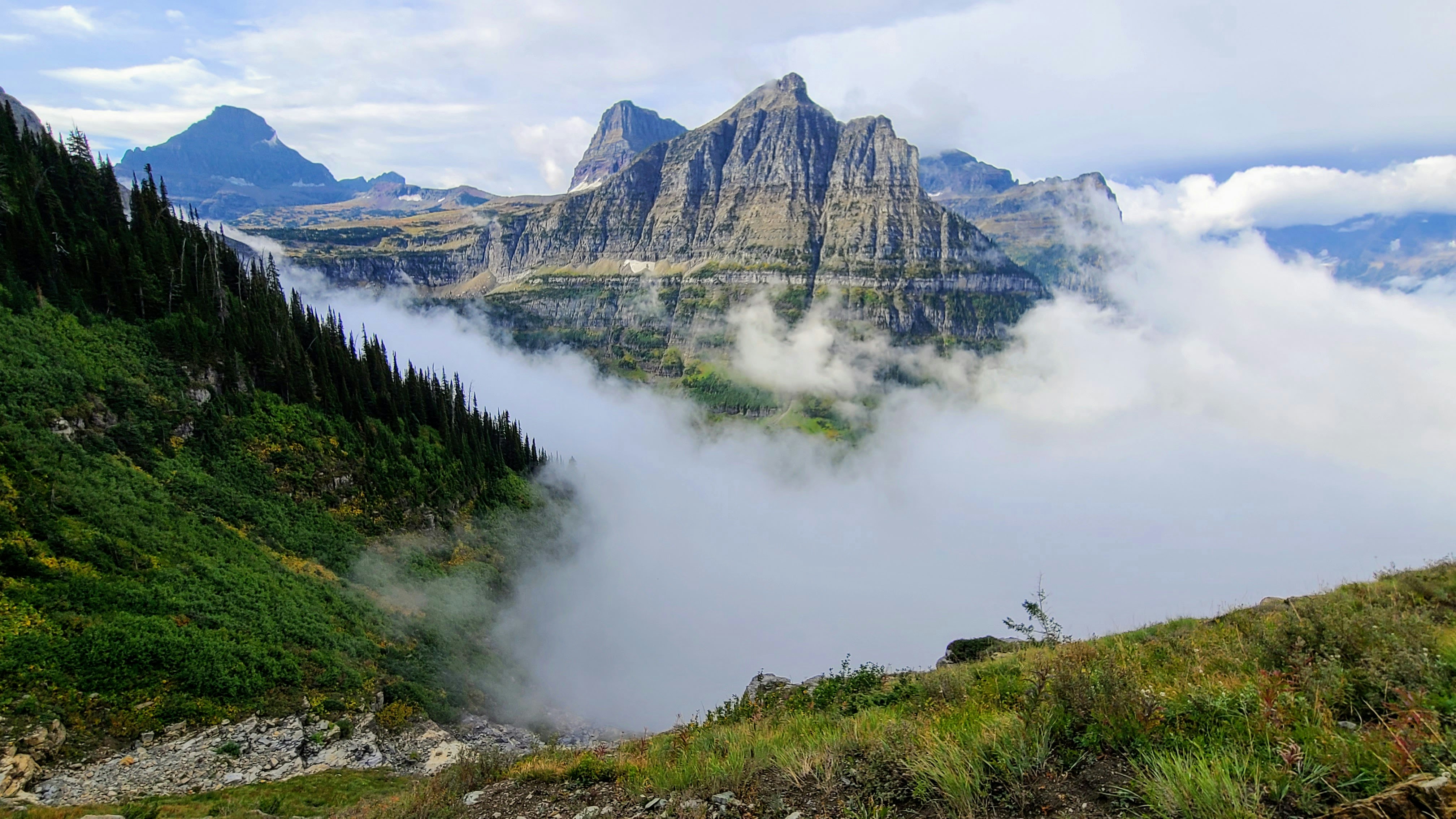 a view of a mountain range with low lying clouds