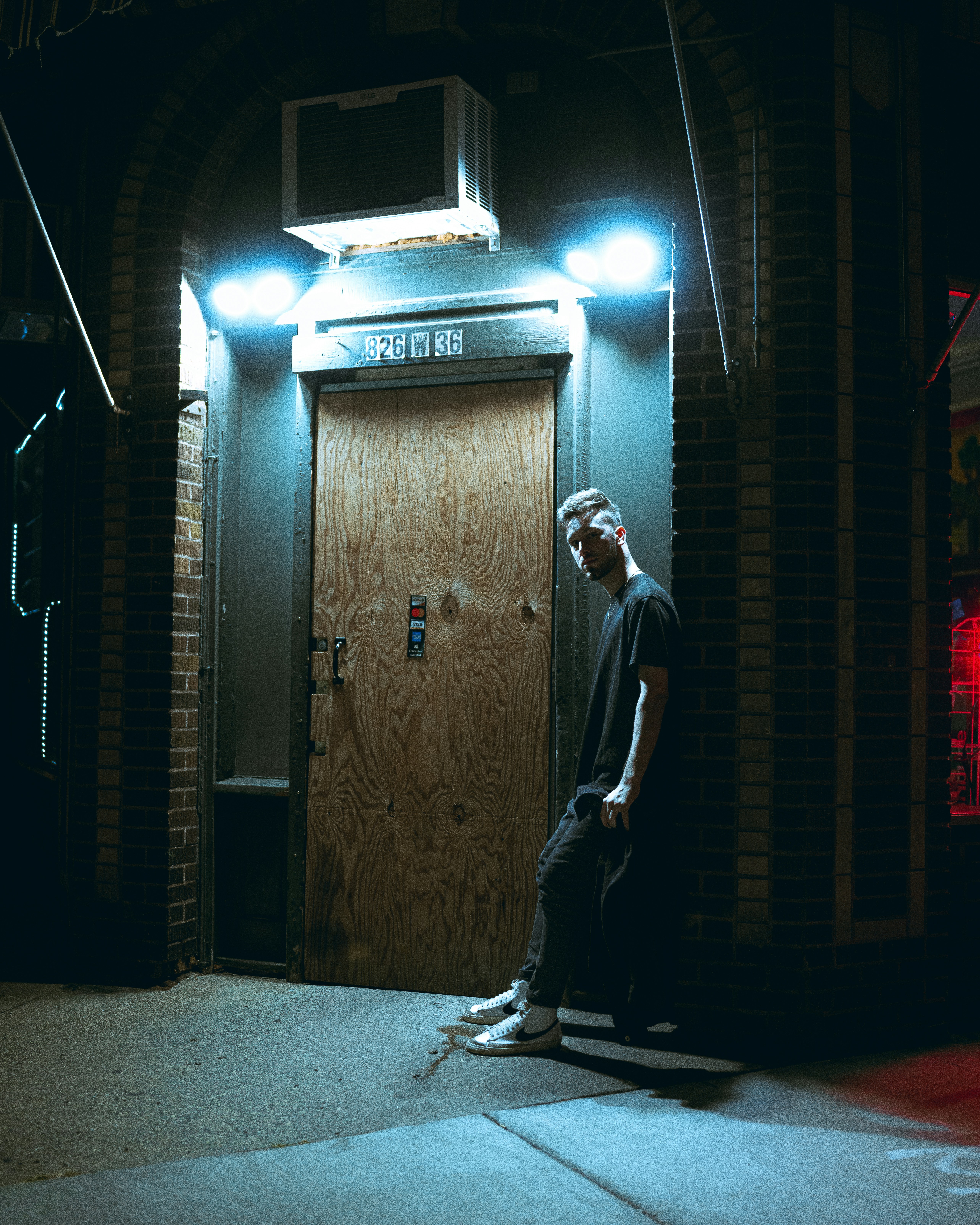 a man standing in front of a door at night