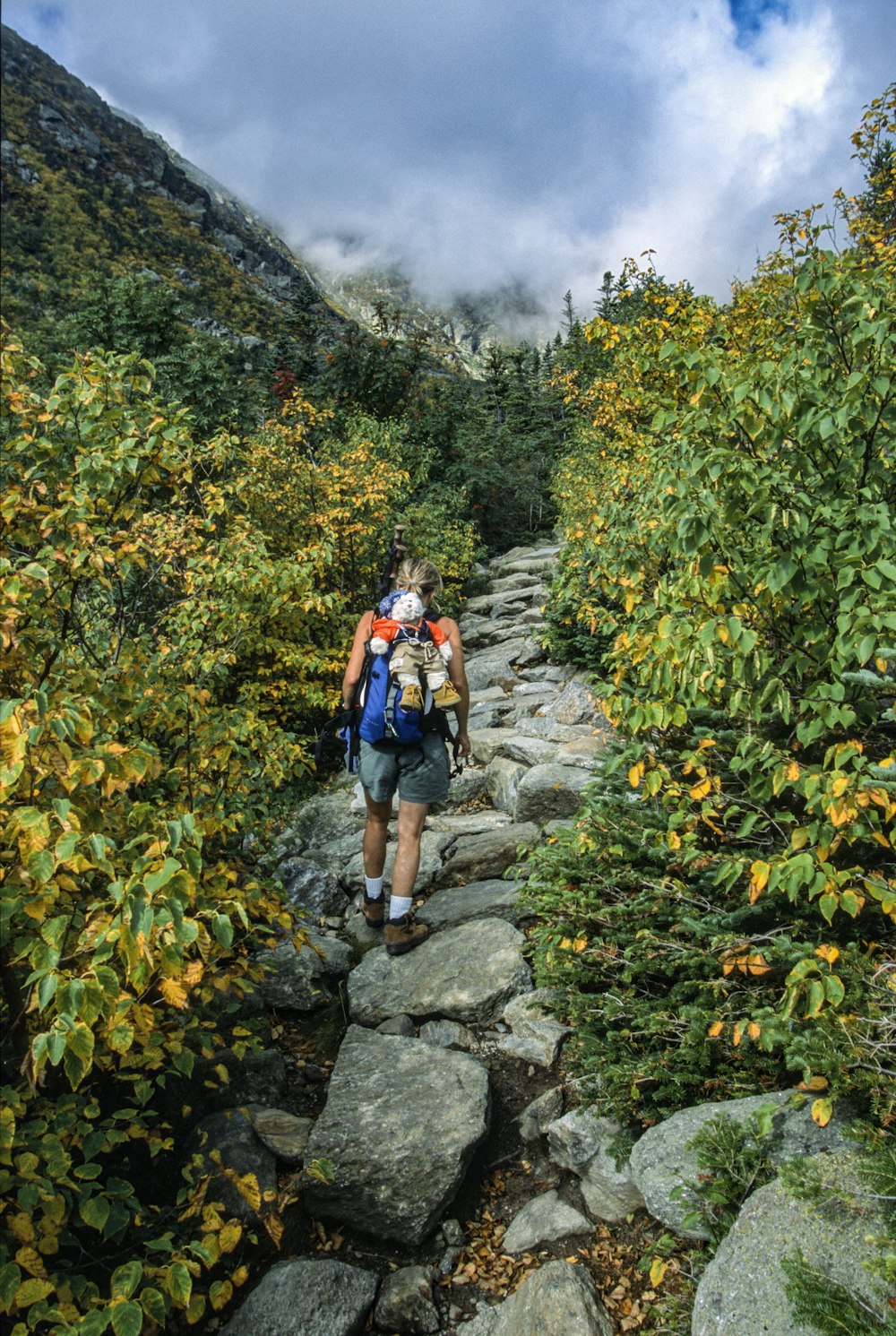 a man hiking up a rocky trail in the mountains