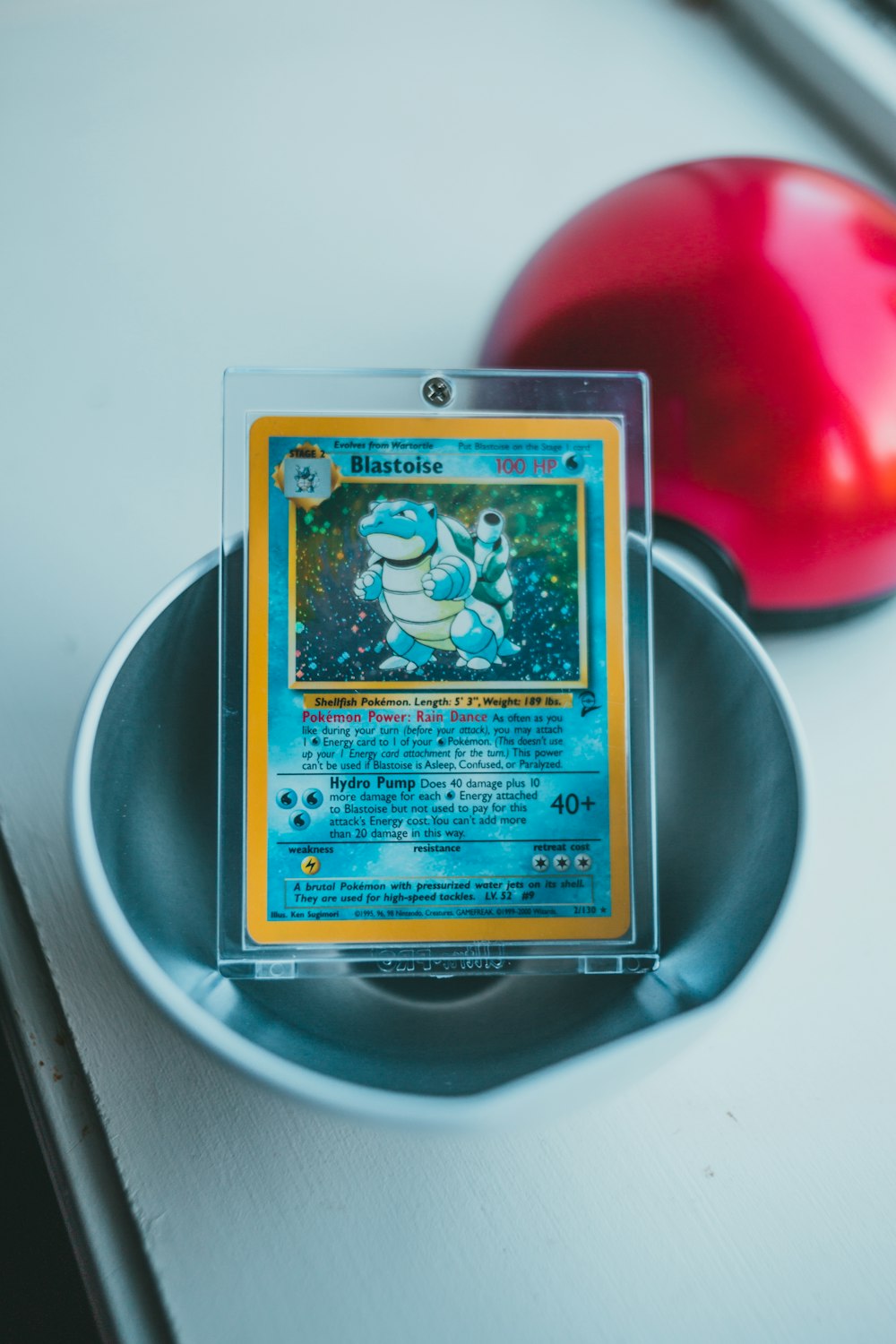 a pokemon card sitting in a bowl next to an apple