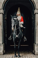 a man in a uniform riding a horse