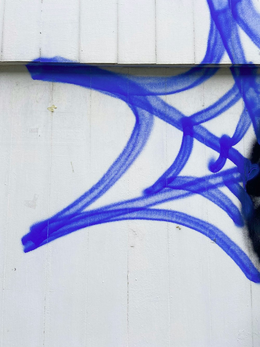 a white building with blue graffiti on it