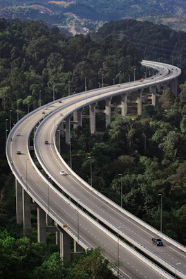 an aerial view of a highway in the middle of a forest