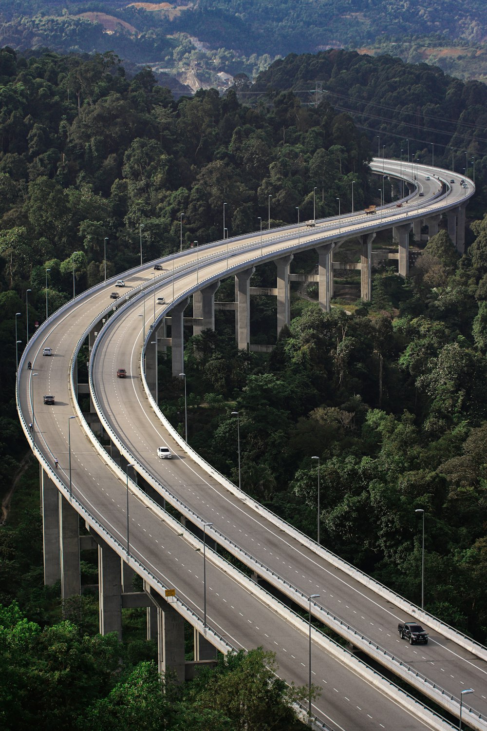 an aerial view of a highway in the middle of a forest