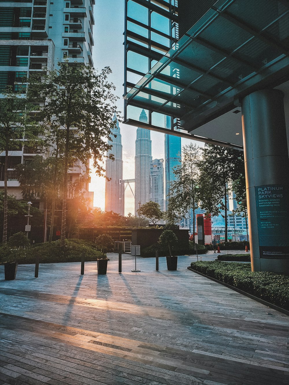 the sun is setting in a city with tall buildings