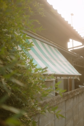 Close-up of a high-end black and gold motorized awning fabric in a minimalist garden setting.
