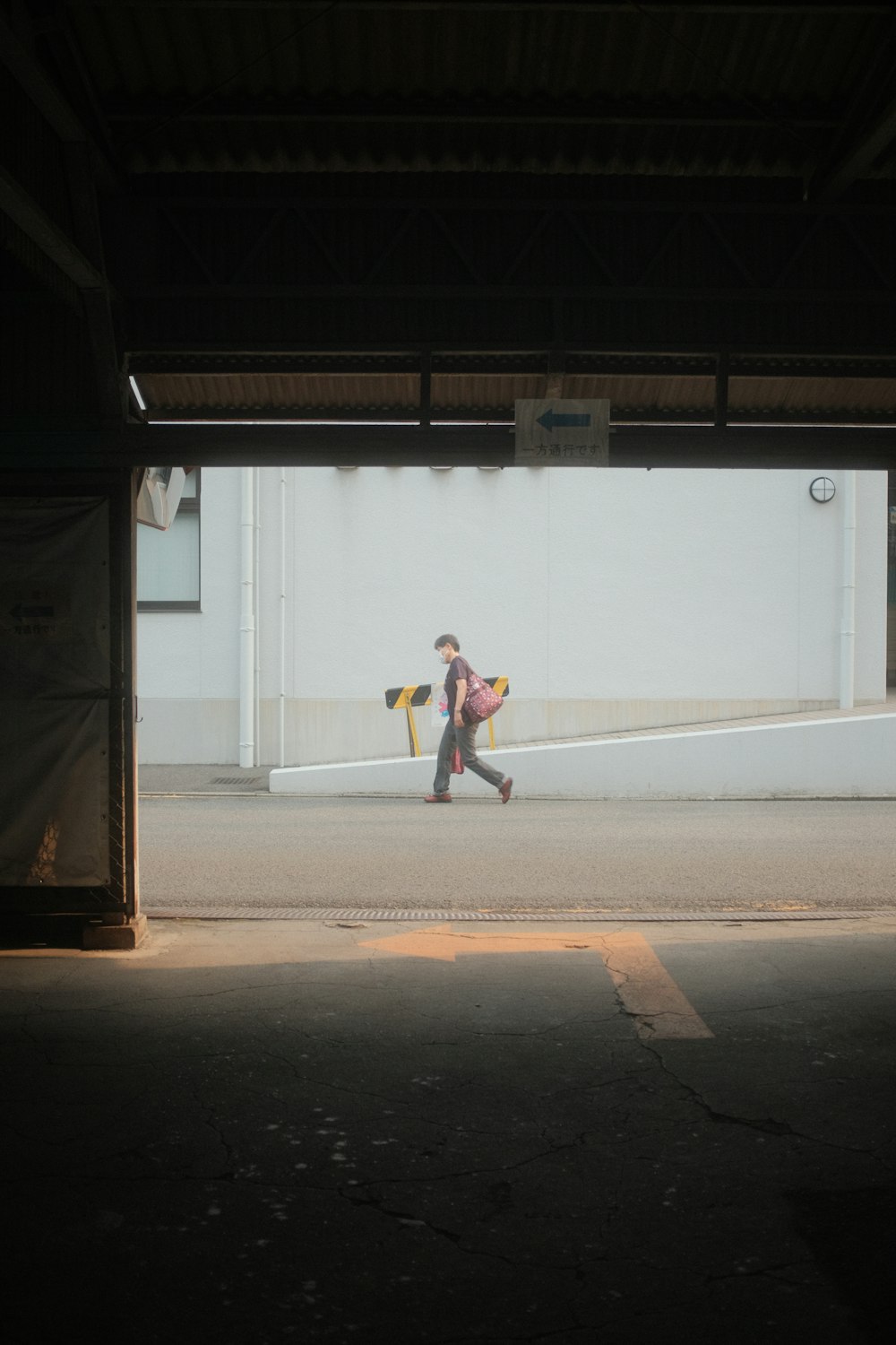 a person walking down a street in a parking garage