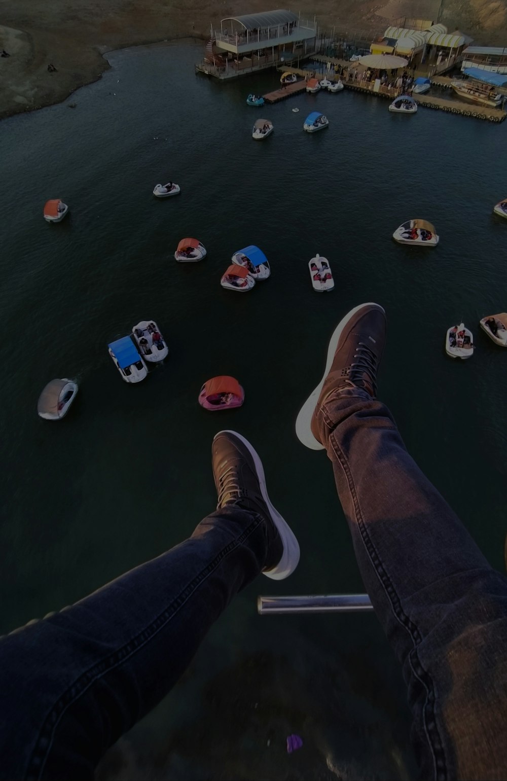 a person standing on a dock with boats in the water