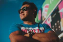 a man wearing sunglasses standing in front of a wall