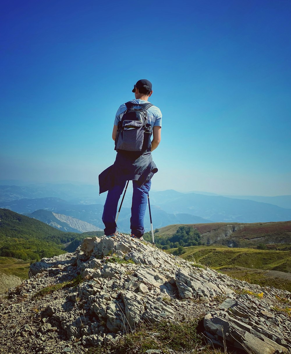 a man standing on top of a rock covered hillside