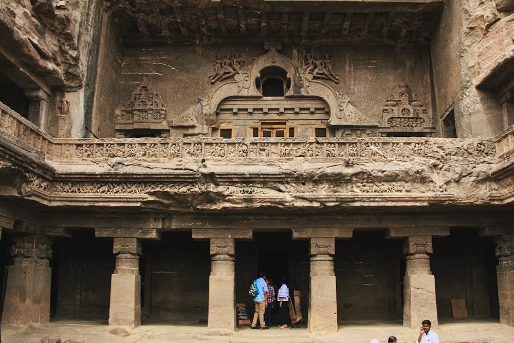 a group of people standing outside of a stone building