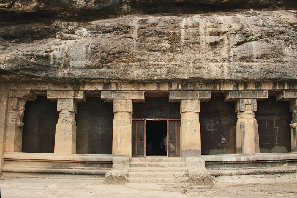 un grande edificio in pietra con colonne e un portale