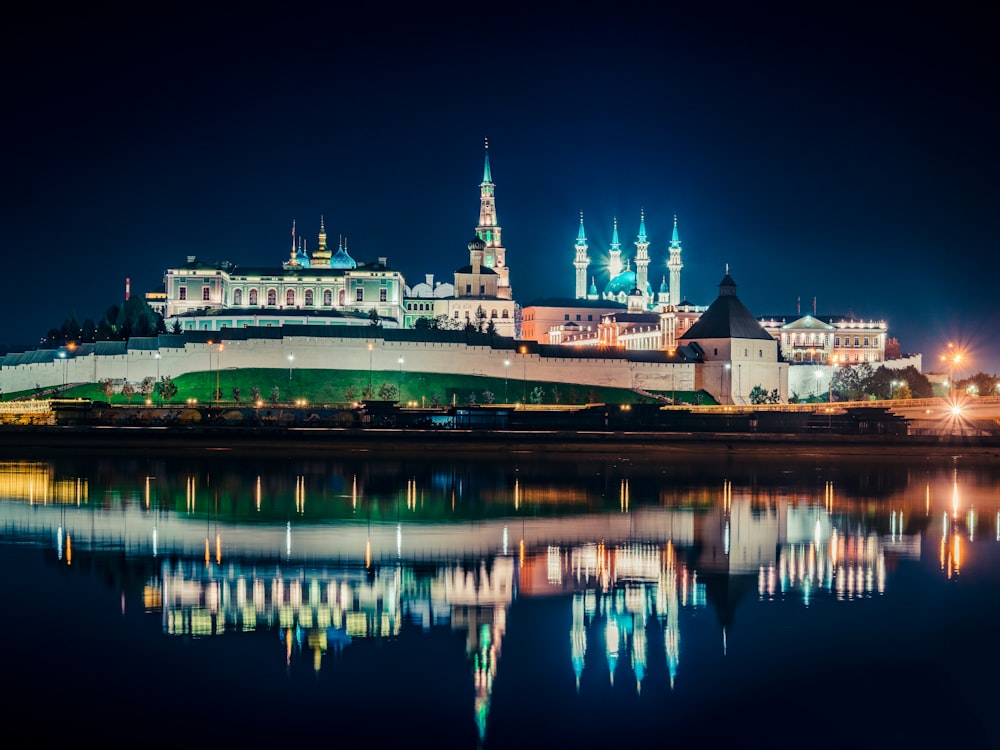 a large building with a clock tower next to a body of water