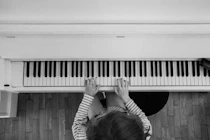 a person playing a piano on a wooden floor