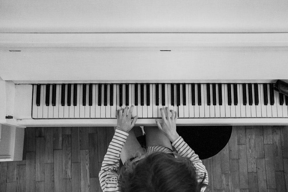 a person playing a piano on a wooden floor