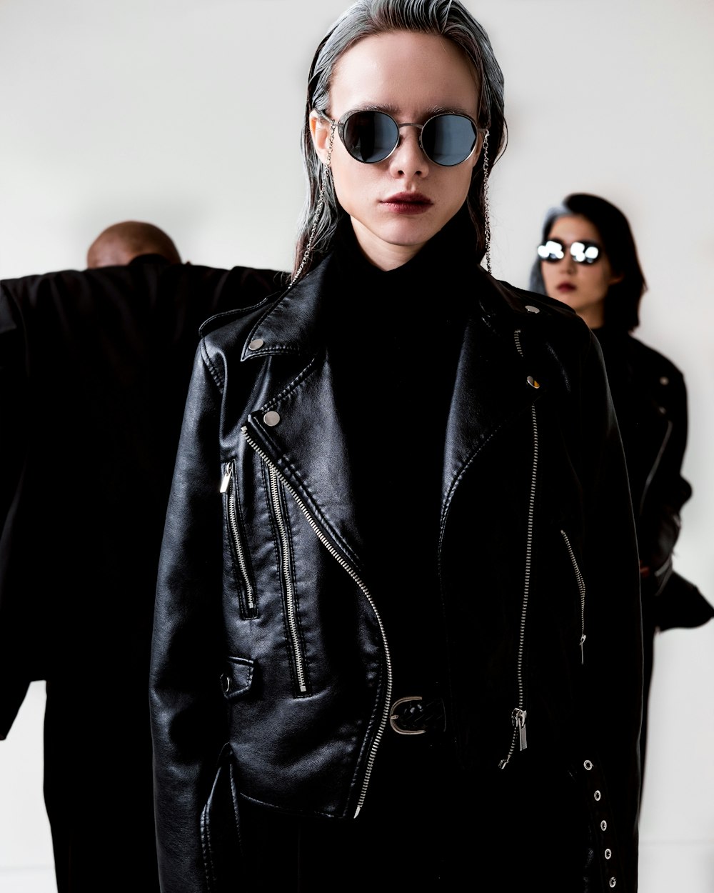 a woman wearing a black leather jacket and sunglasses