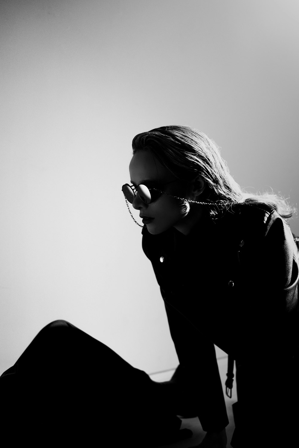 a woman sitting on the ground wearing sunglasses