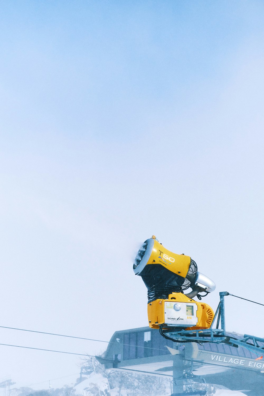 a yellow and black robot is on top of a ski lift
