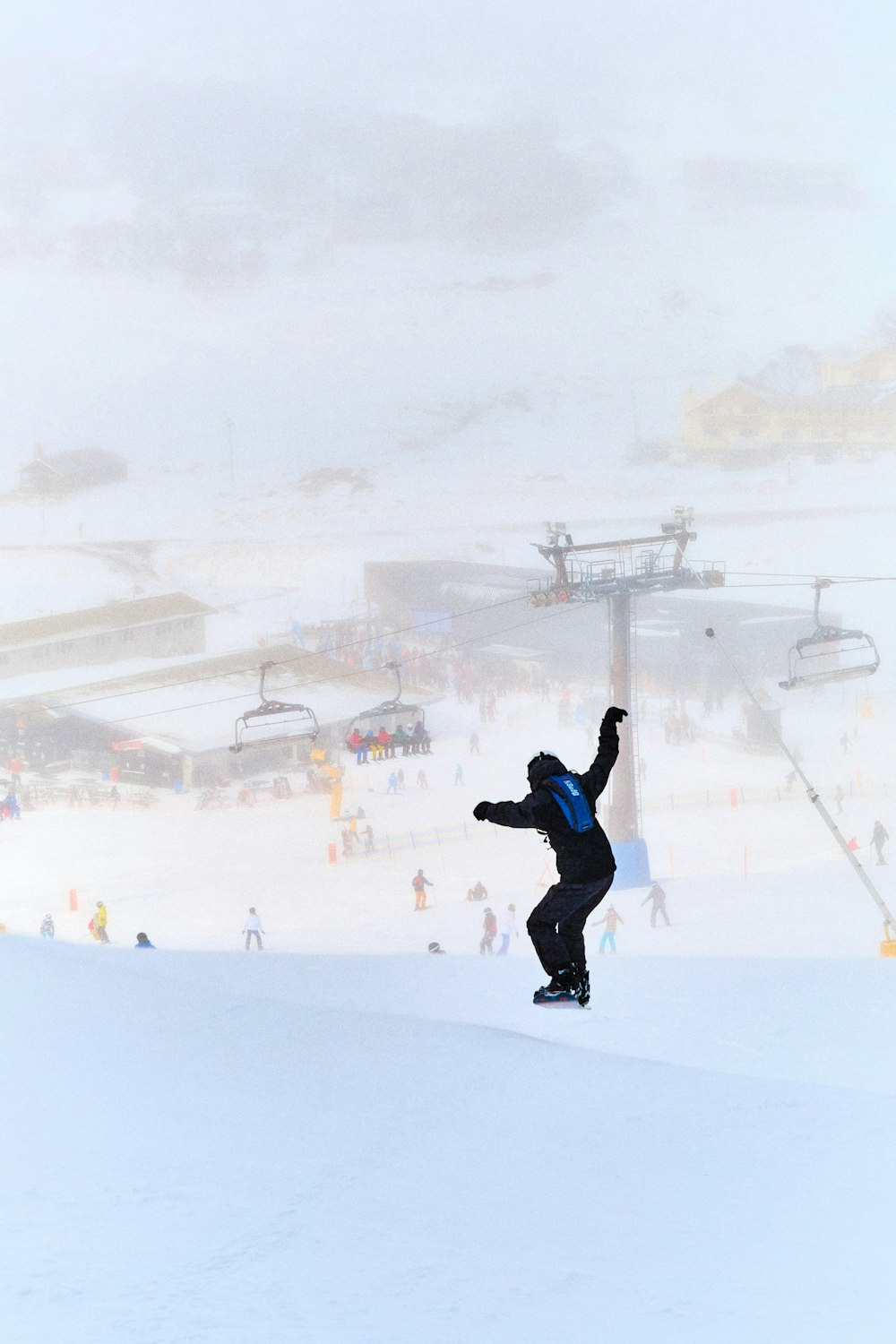 a man riding a snowboard down a snow covered slope