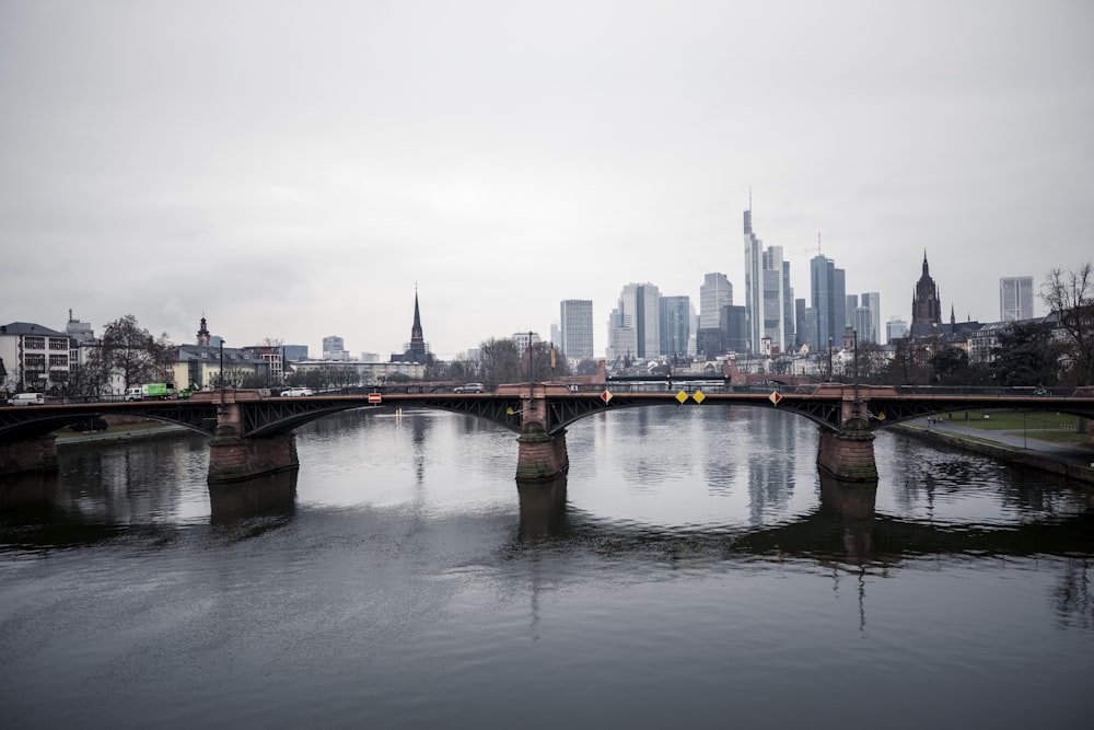 a bridge over a body of water with a city in the background