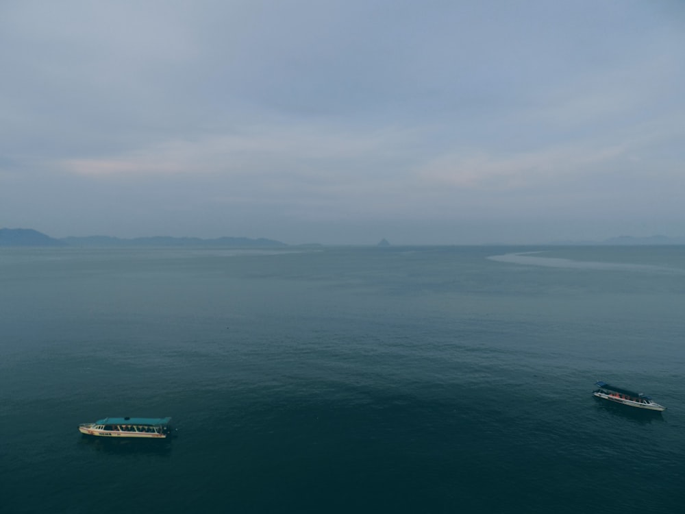 a couple of boats floating on top of a large body of water