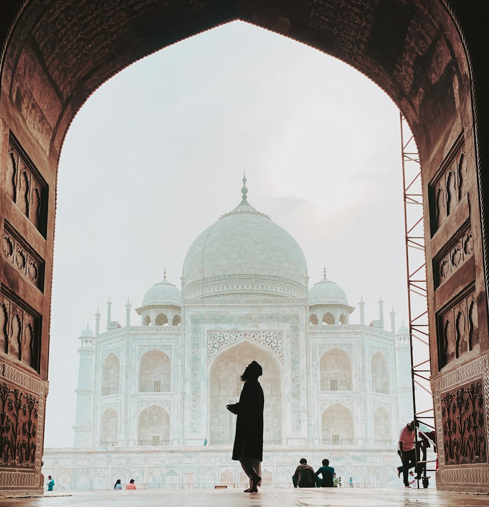 a person standing in front of a white building