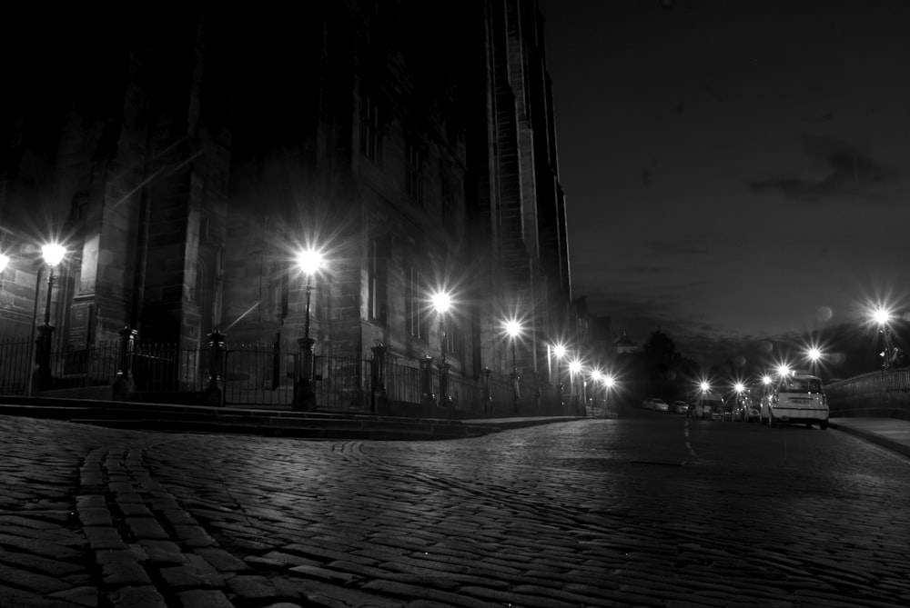 a black and white photo of a street at night