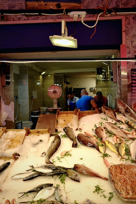 Close-up of fresh catfish fillets displayed on ice at a rustic market stall.