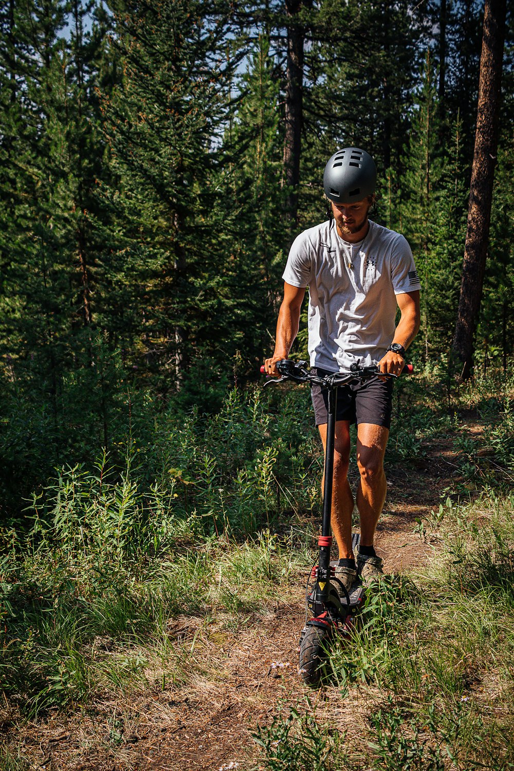 a man riding a scooter through a forest