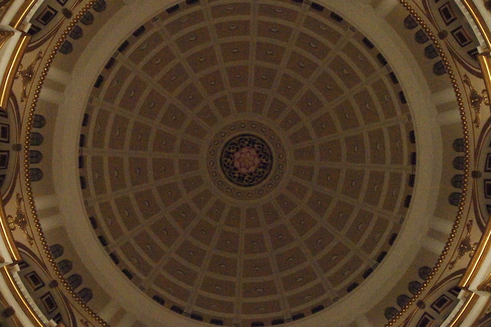 the ceiling of a building with a clock on it