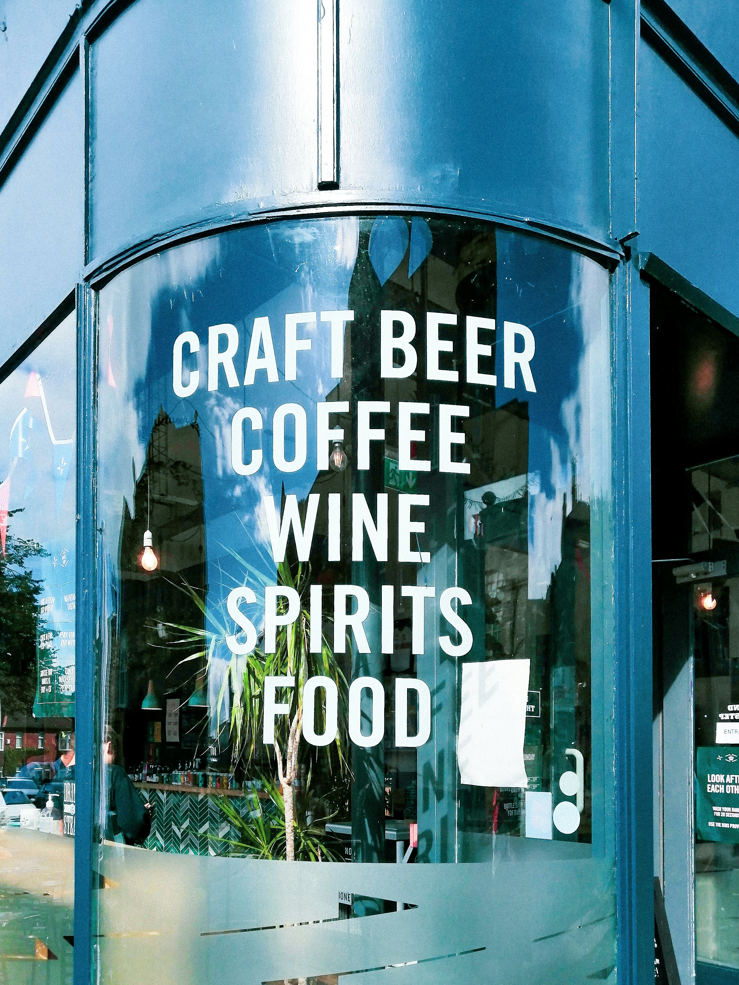 a blue building with a sign that says craft beer coffee wine spirits food