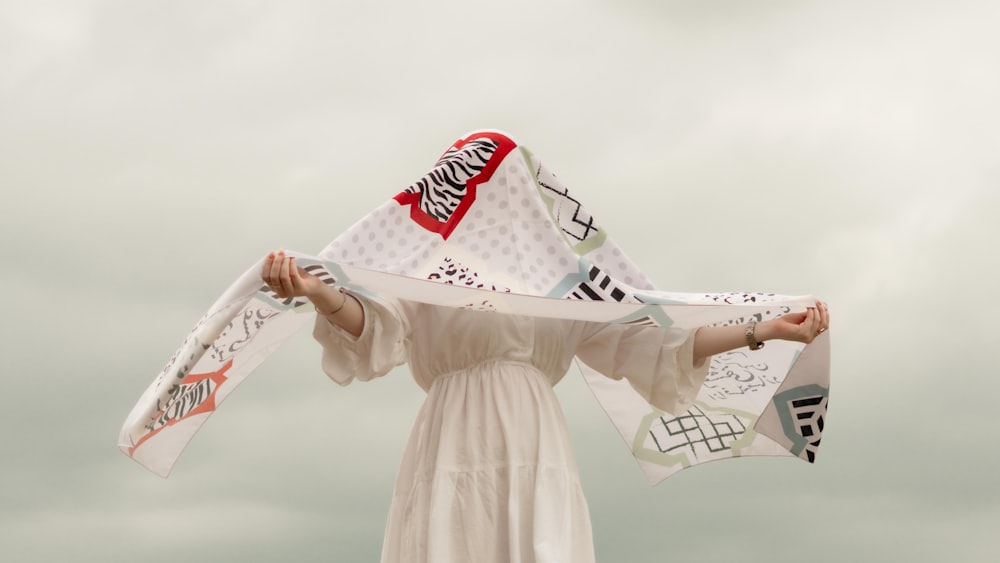 a woman in a white dress holding a kite