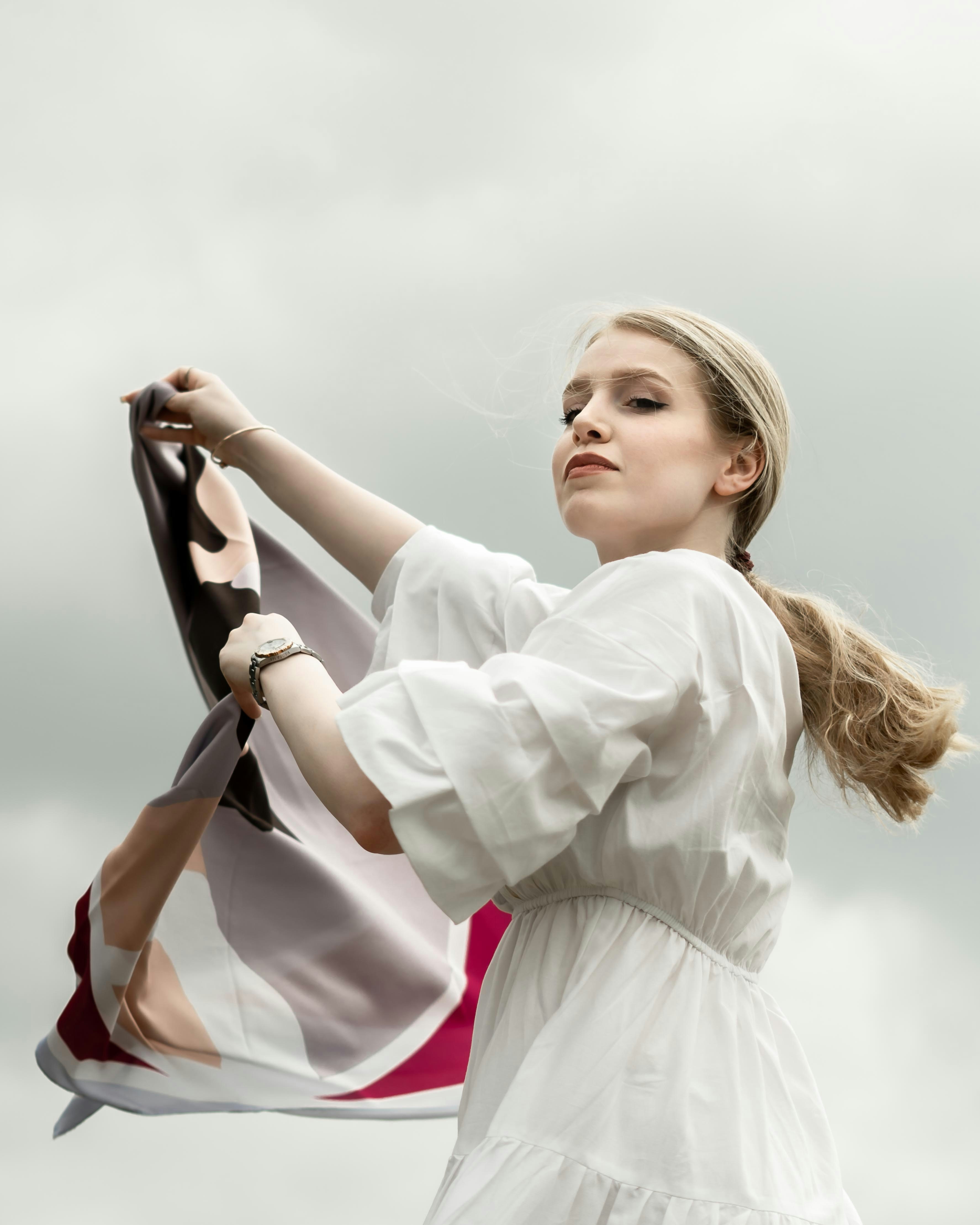 a woman in a white dress holding a flag