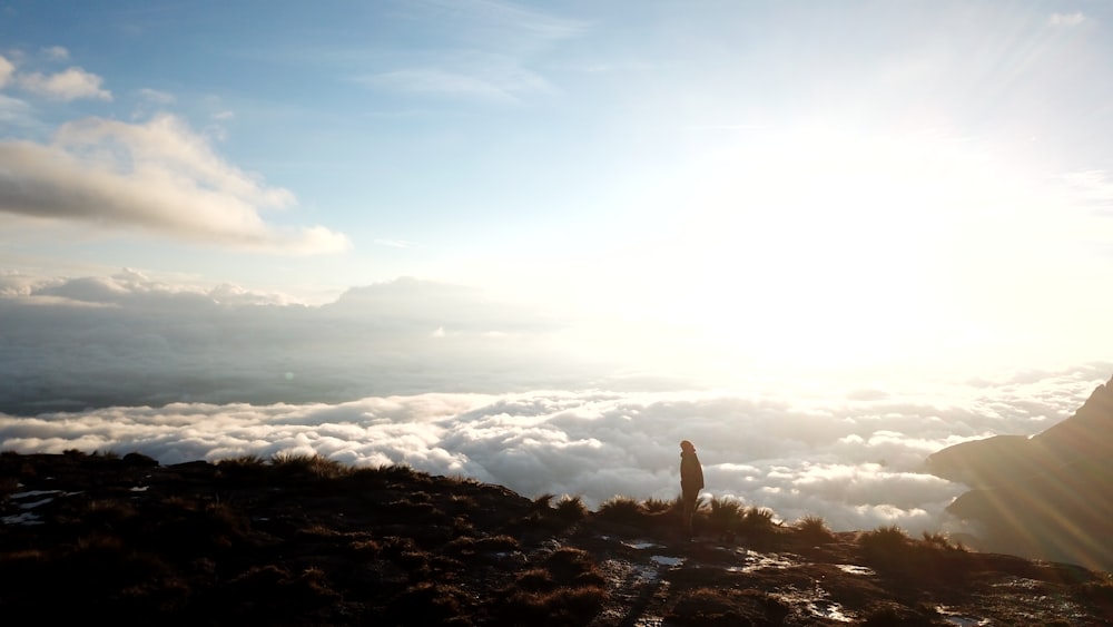 a person standing on top of a mountain above the clouds