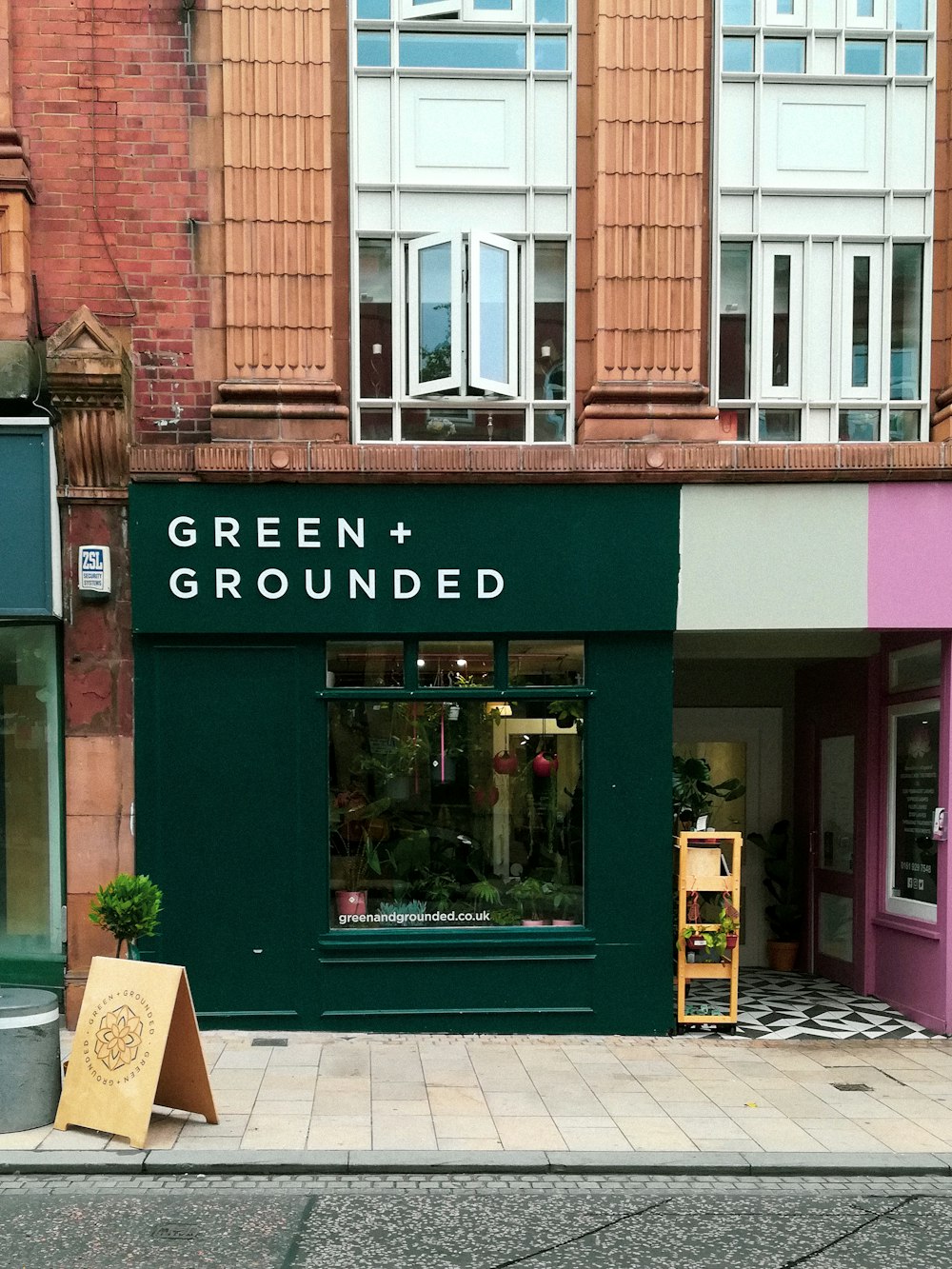 a green and pink store front on a city street