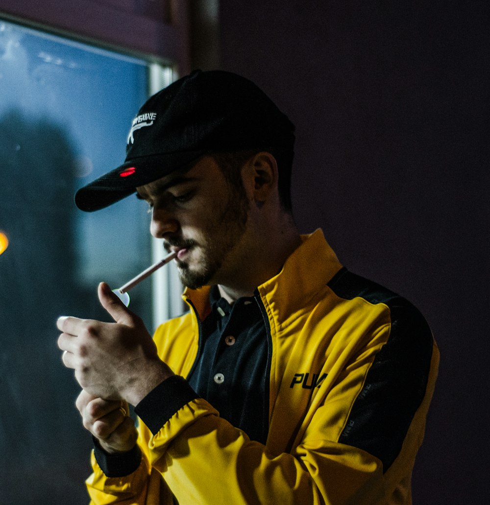 a man in a yellow jacket smoking a cigarette