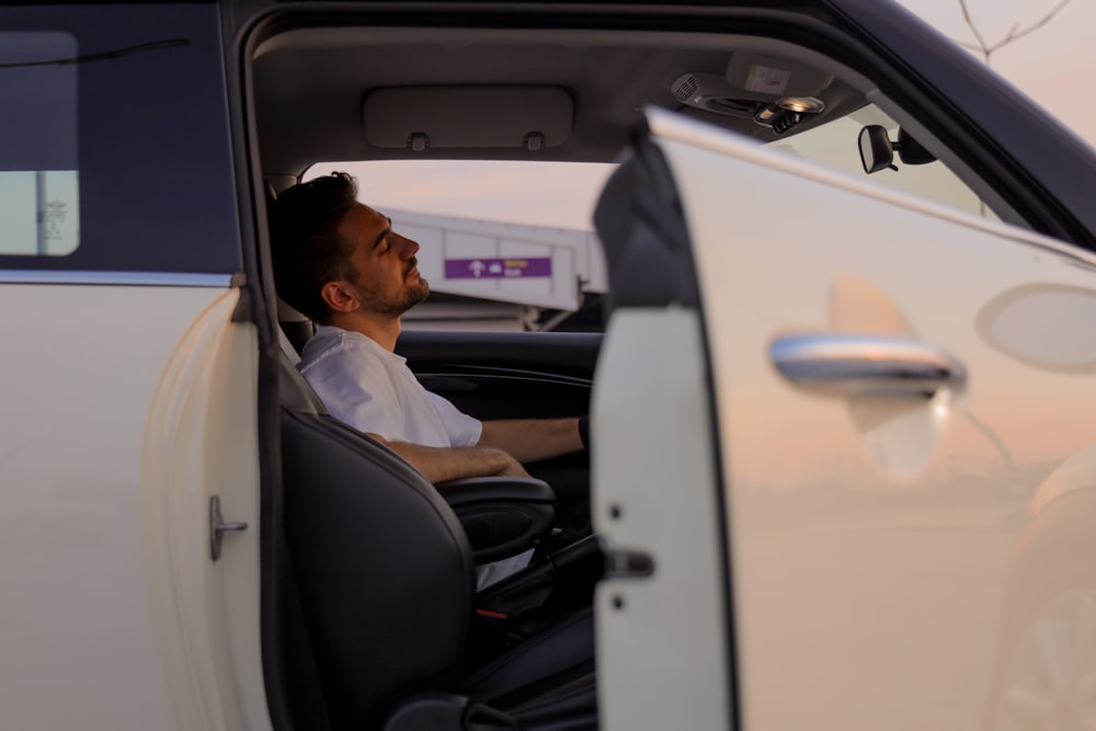 a man sitting in the driver's seat of a car