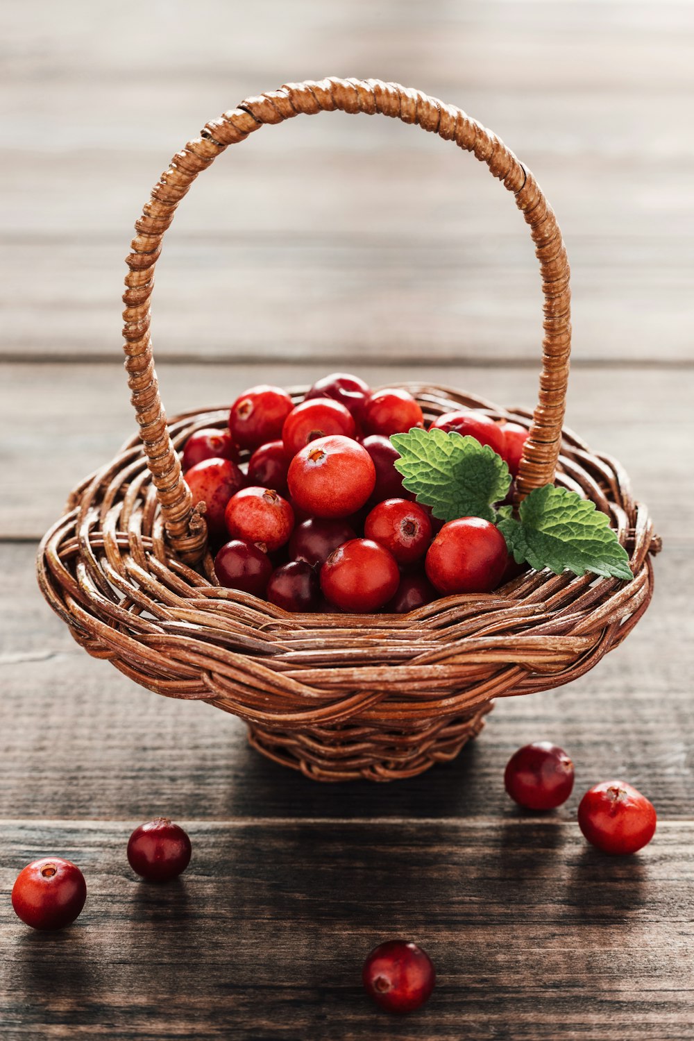 a basket filled with cherries on top of a wooden table