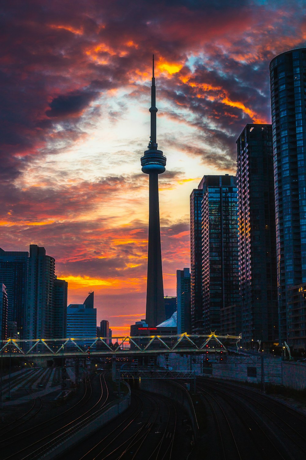 a city skyline at sunset with a train track in the foreground