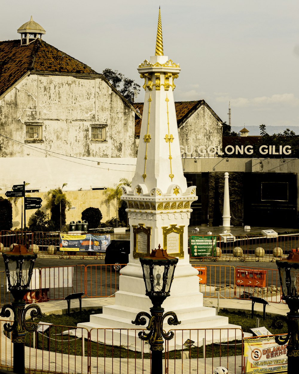 a white and gold clock tower sitting in the middle of a park