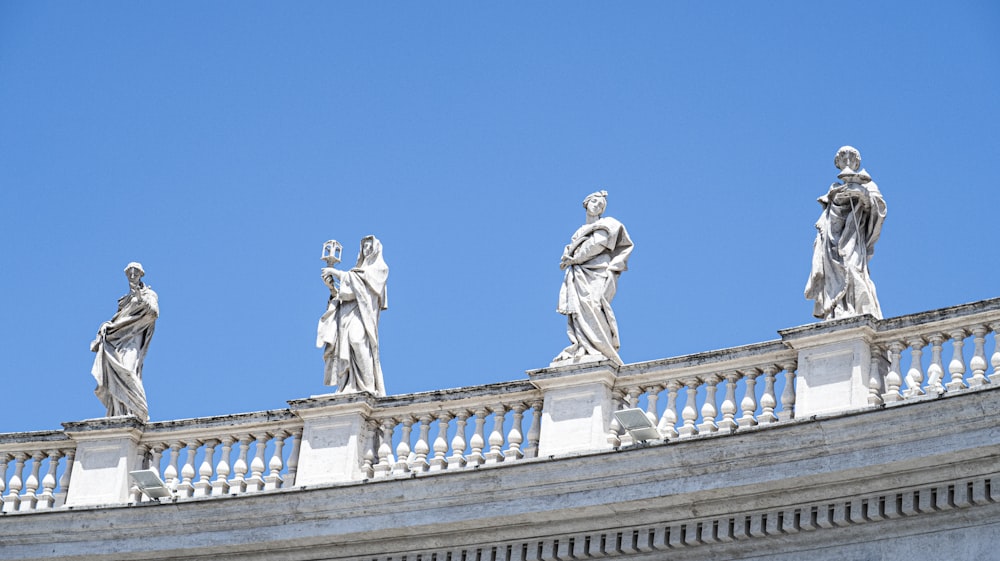 a group of statues on top of a building