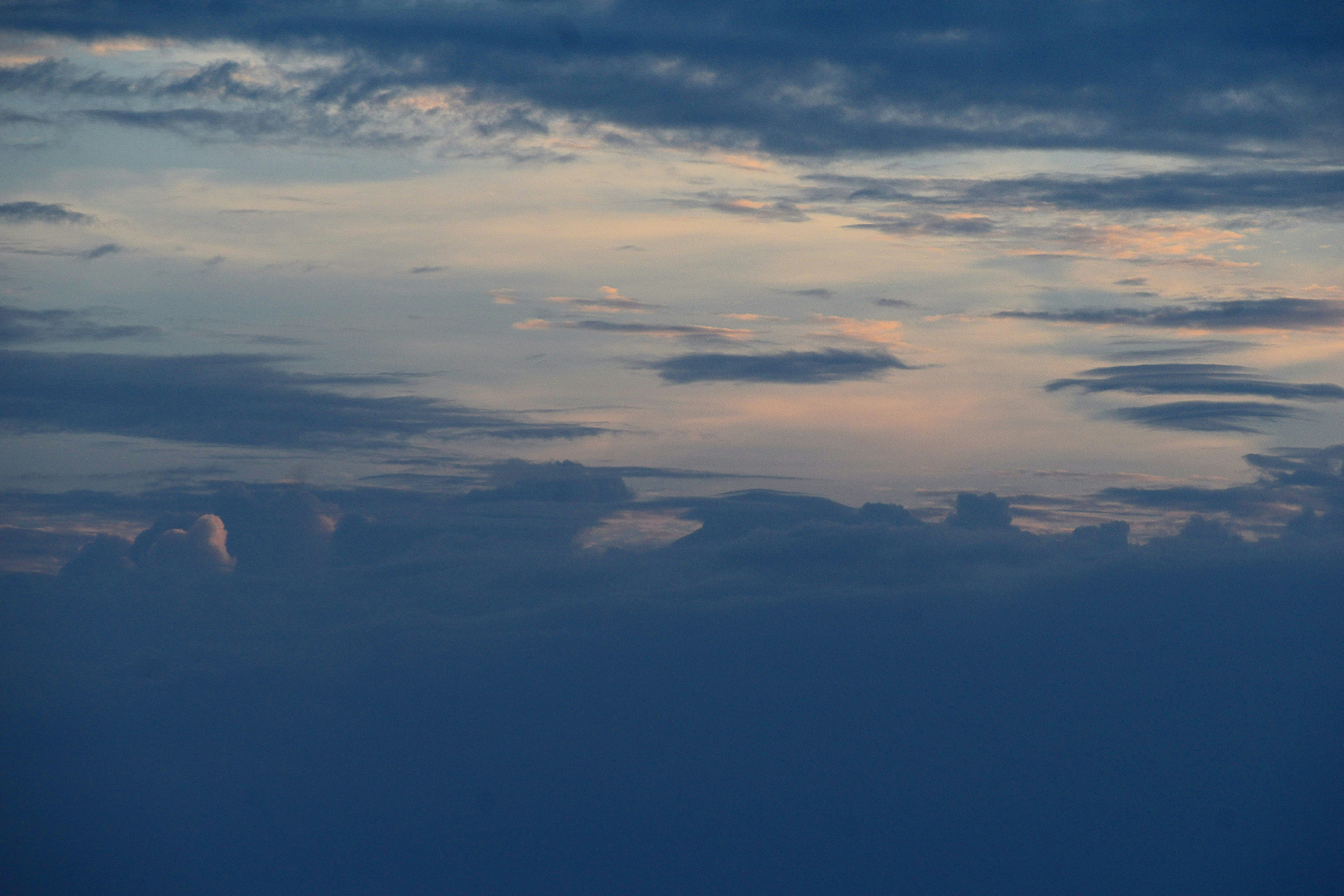 Ein Flugzeug, das in der Abenddämmerung durch einen bewölkten Himmel fliegt