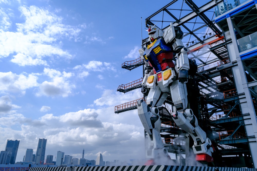 Una estatua de un robot gigante parado frente a un edificio alto