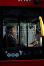 a man sitting in a bus driving down the street