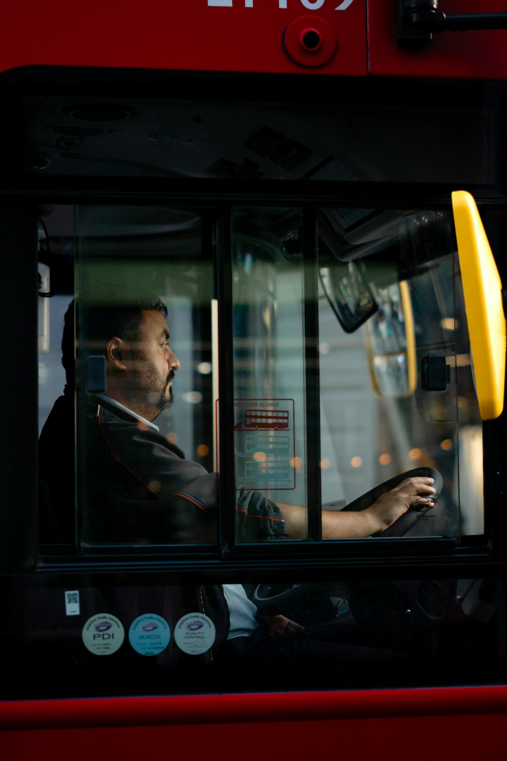 通りを運転するバスに座っている男性